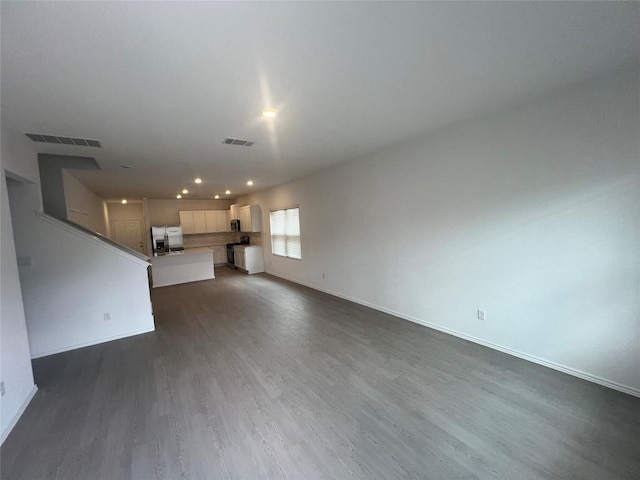 151 Cibolo Creek Loop, Bastrop, TX 78602 - unfurnished living room featuring dark wood-style flooring, baseboards, and recessed lighting
