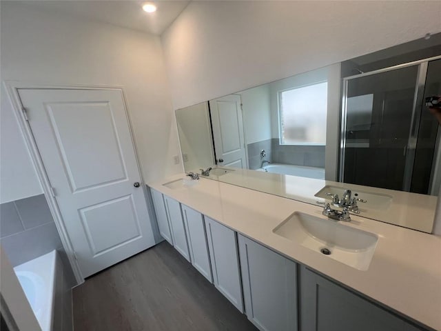 151 Cibolo Creek Loop, Bastrop, TX 78602 - full bath with a bath, a shower stall, wood finished floors, double vanity, and recessed lighting