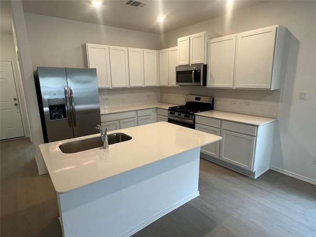 151 Cibolo Creek Loop, Bastrop, TX 78602 - kitchen featuring stainless steel appliances, a sink, backsplash, and dark wood-style flooring