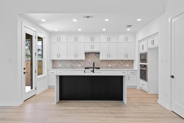 5804 Kelly Kyle Ave, Georgetown, TX 78628 - kitchen featuring appliances with stainless steel finishes, light countertops, backsplash, white cabinetry, and recessed lighting