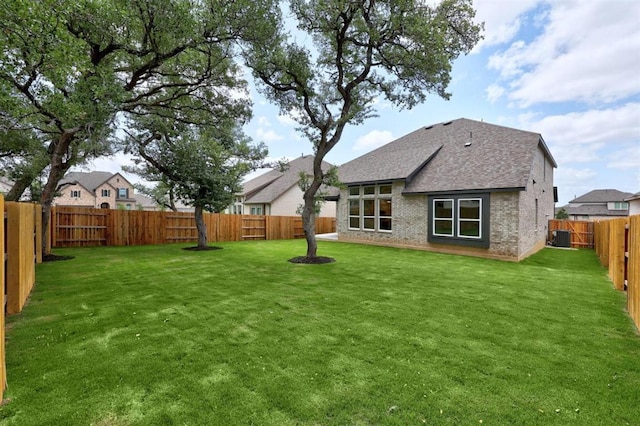 5804 Kelly Kyle Ave, Georgetown, TX 78628 - rear view of house featuring roof with shingles, brick siding, and a fenced backyard
