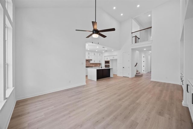 5804 Kelly Kyle Ave, Georgetown, TX 78628 - unfurnished living room with a ceiling fan, light wood-type flooring, recessed lighting, and a high ceiling