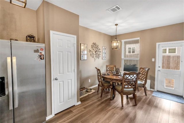 dining room featuring visible vents, baseboards, and wood finished floors