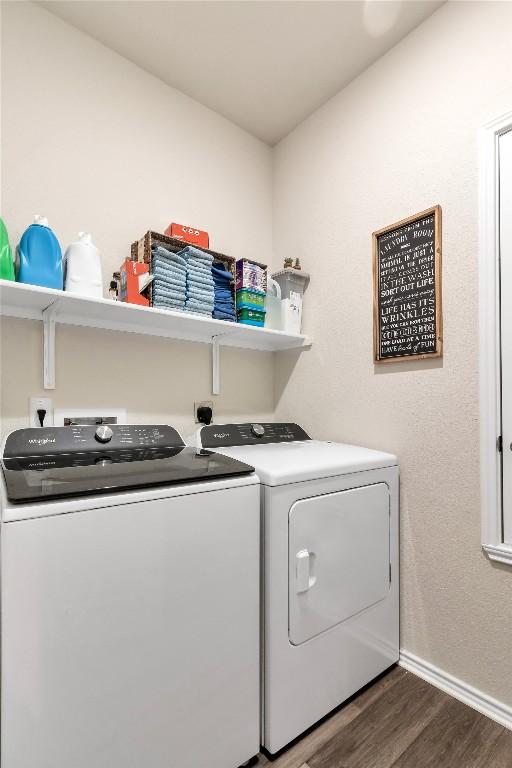 laundry area with washing machine and dryer, laundry area, baseboards, and wood finished floors