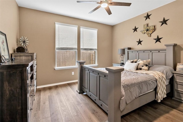 bedroom with ceiling fan, baseboards, and wood finished floors