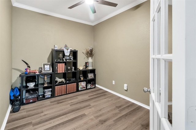 interior space featuring crown molding, baseboards, and wood finished floors