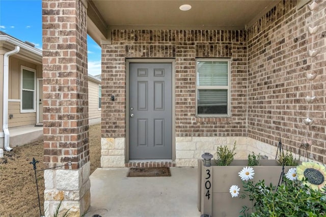 view of exterior entry with brick siding