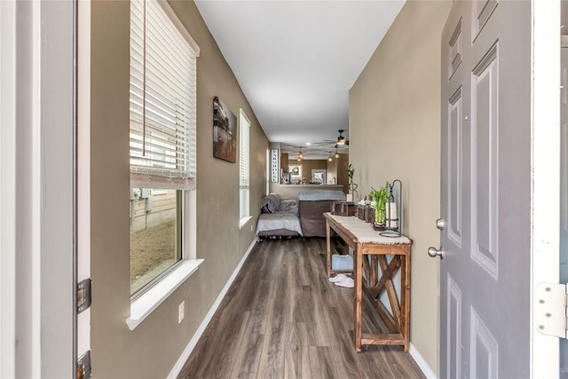 hallway with dark wood-style flooring and baseboards