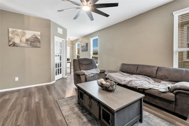 living area with a ceiling fan, visible vents, baseboards, and wood finished floors