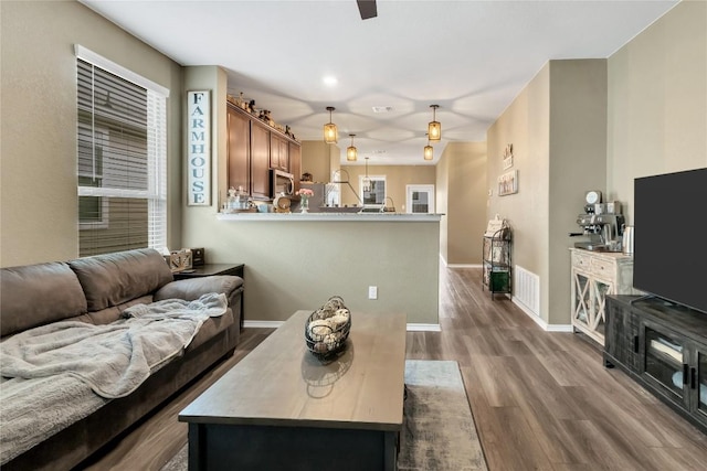 living area featuring dark wood finished floors, visible vents, and baseboards