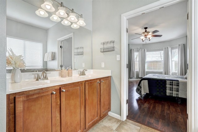 full bathroom featuring a ceiling fan, double vanity, a sink, and tile patterned floors