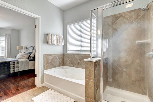 full bathroom with a stall shower, tile patterned flooring, a garden tub, and ensuite bath