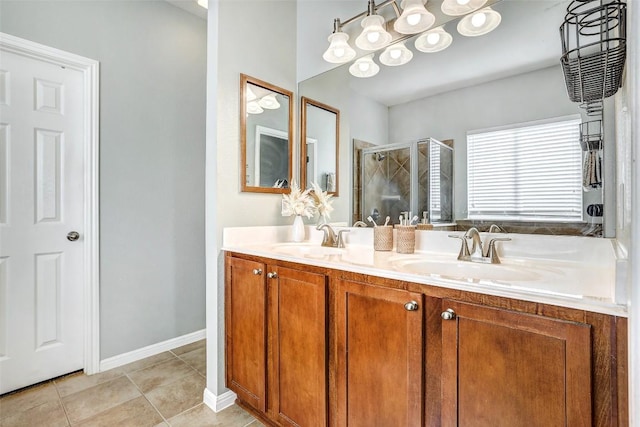 full bathroom featuring double vanity, a stall shower, tile patterned flooring, and a sink