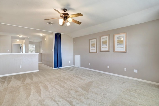 empty room with visible vents, baseboards, light colored carpet, lofted ceiling, and ceiling fan