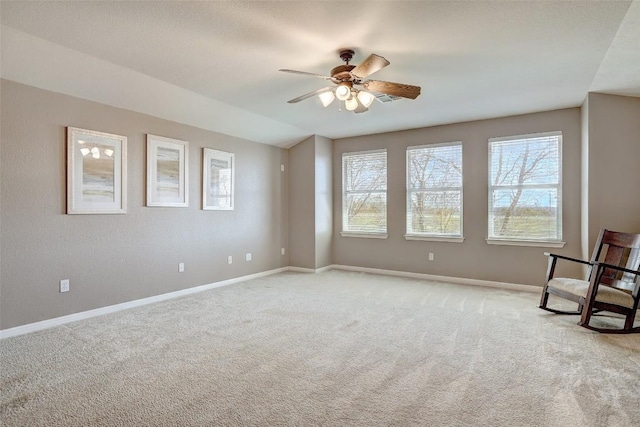 unfurnished room featuring light carpet, plenty of natural light, baseboards, and ceiling fan