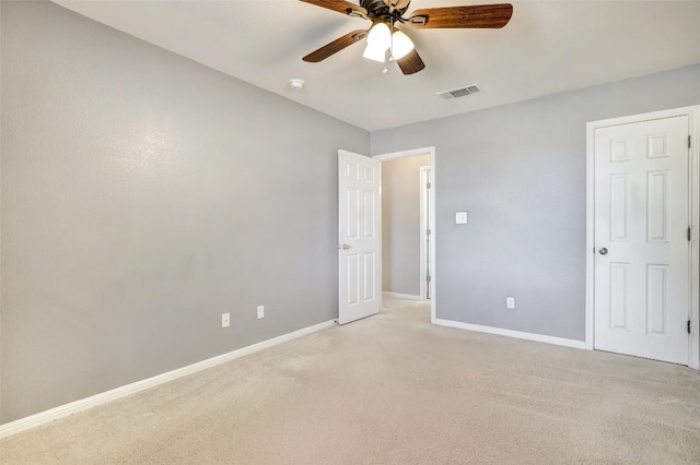 unfurnished bedroom with a ceiling fan, light colored carpet, visible vents, and baseboards