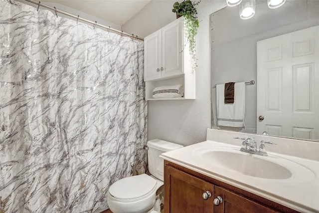 bathroom featuring toilet, a shower with shower curtain, and vanity