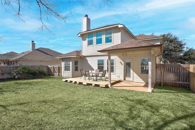 rear view of property with a fenced backyard, a chimney, roof with shingles, a yard, and a wooden deck