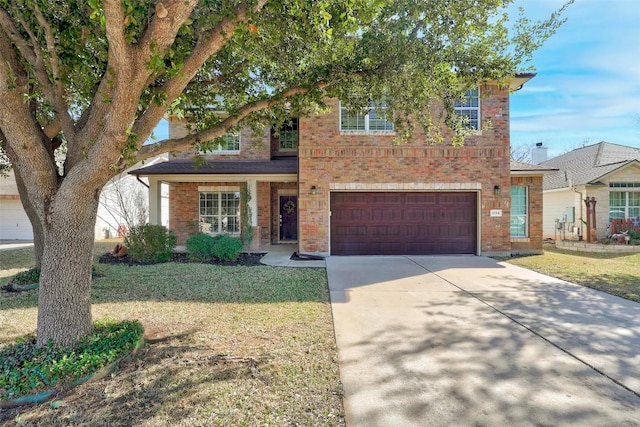 traditional home featuring a garage, a front lawn, concrete driveway, and brick siding