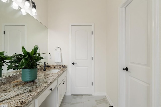 bathroom featuring marble finish floor, vanity, and baseboards