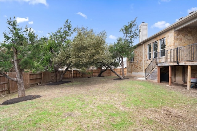 view of yard with a fenced backyard and stairs