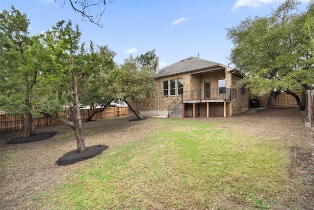 rear view of house with stairs, a lawn, and a fenced backyard