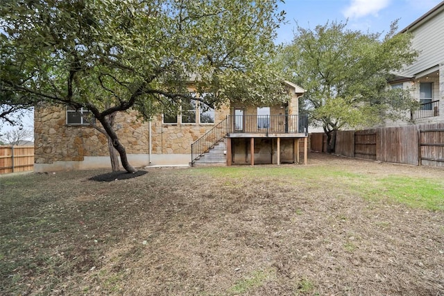 view of yard with a fenced backyard and stairway