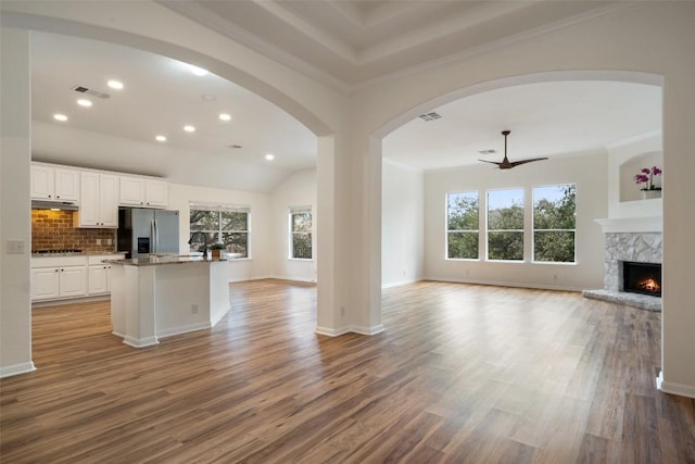 kitchen with visible vents, stainless steel fridge with ice dispenser, open floor plan, wood finished floors, and white cabinetry