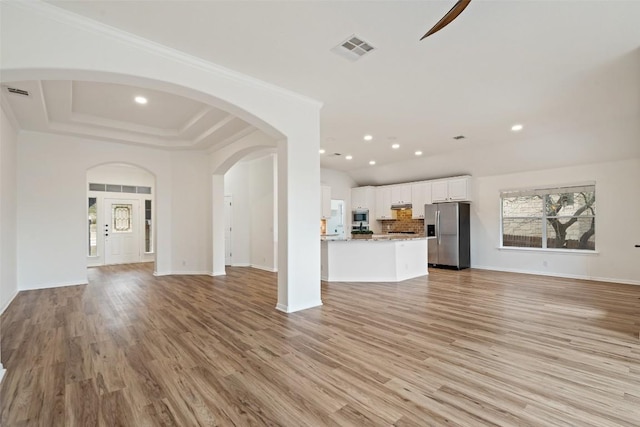 unfurnished living room featuring ornamental molding, visible vents, and light wood-style flooring