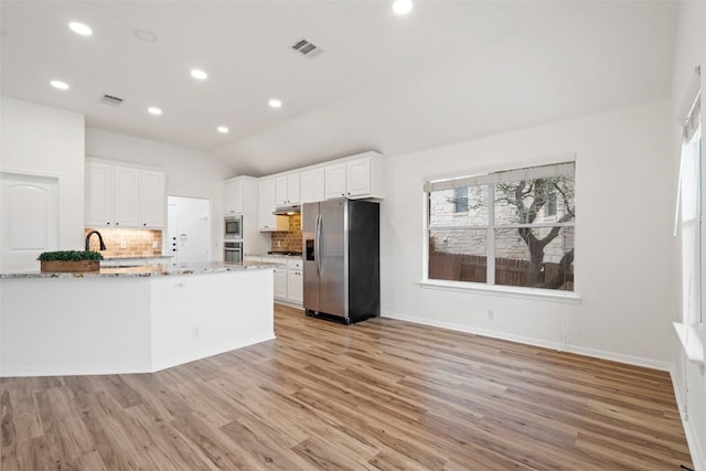 kitchen featuring stainless steel appliances, white cabinets, visible vents, and light wood-style floors