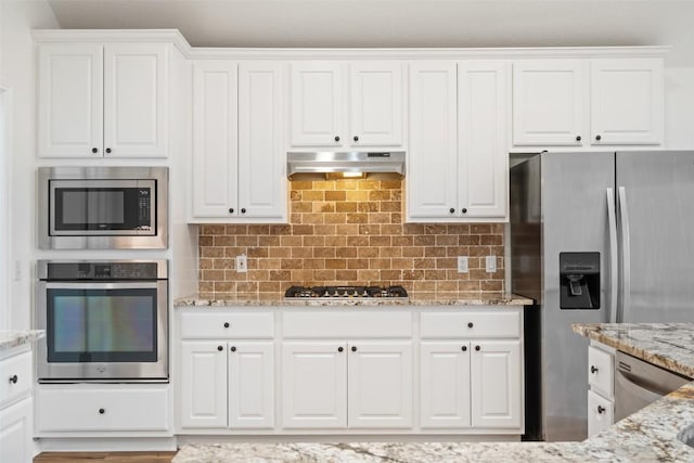 kitchen featuring stainless steel appliances, tasteful backsplash, white cabinetry, and under cabinet range hood