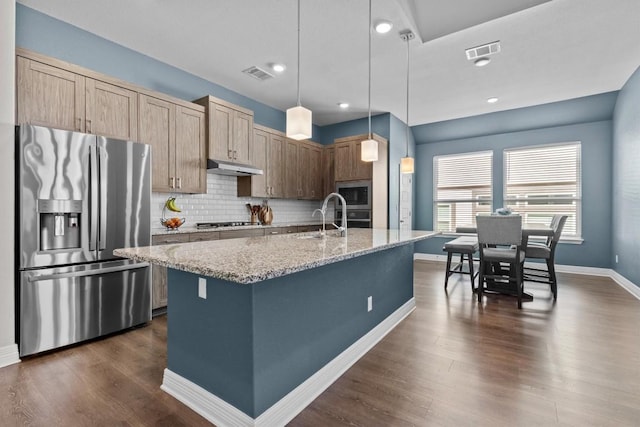 kitchen with under cabinet range hood, visible vents, appliances with stainless steel finishes, and a sink