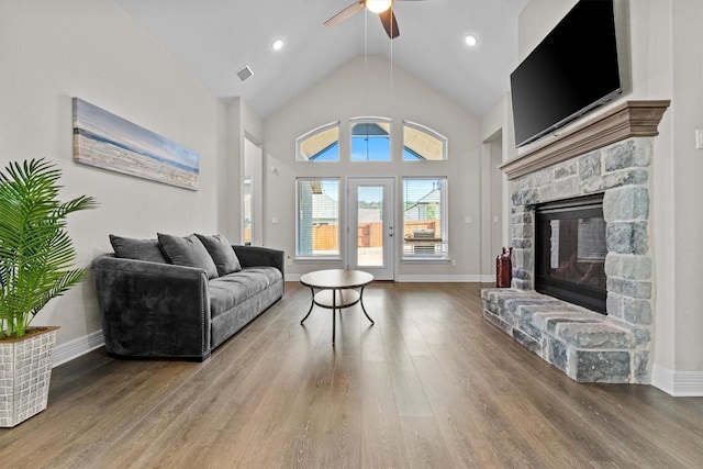 living area featuring a fireplace, baseboards, and wood finished floors