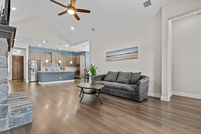 living room with high vaulted ceiling, visible vents, ceiling fan, and wood finished floors