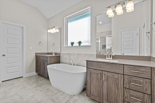 bathroom featuring vaulted ceiling, two vanities, a sink, and a shower stall