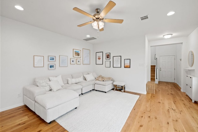 living room with light wood-style flooring, visible vents, and recessed lighting