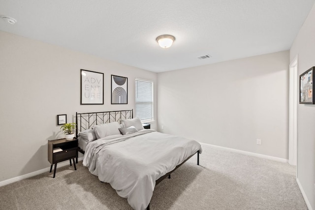 bedroom with visible vents, light carpet, and baseboards