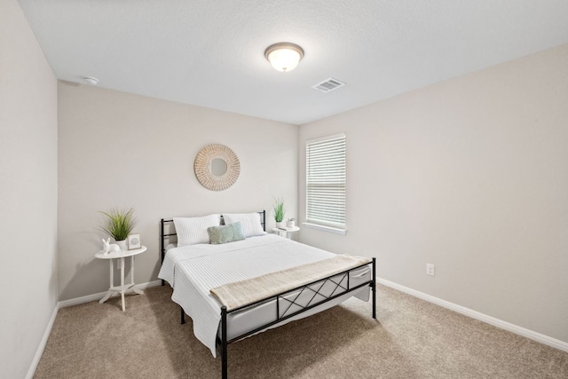 carpeted bedroom with visible vents and baseboards