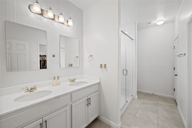 full bathroom with a stall shower, tile patterned floors, a sink, and double vanity