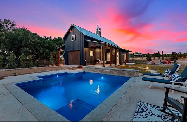 pool with an outbuilding, a patio area, and fence