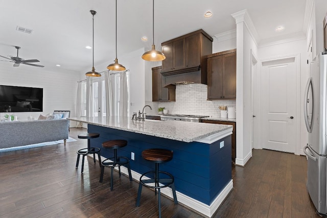 kitchen with visible vents, dark wood finished floors, open floor plan, freestanding refrigerator, and a sink