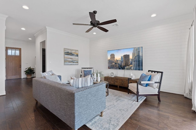 living area with a city view, recessed lighting, visible vents, ornamental molding, and dark wood finished floors