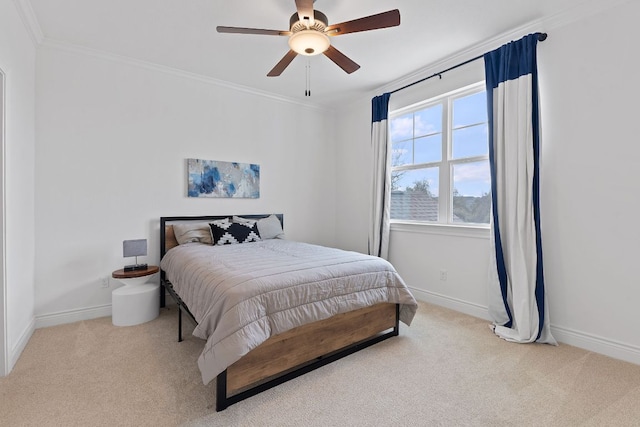 carpeted bedroom with crown molding, baseboards, and ceiling fan