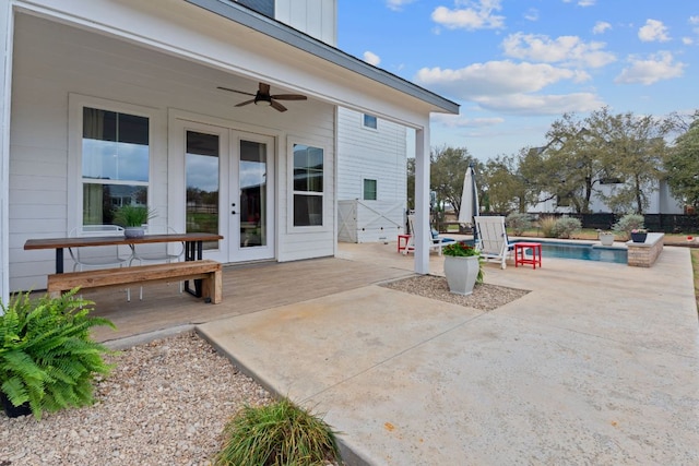 view of patio / terrace featuring ceiling fan, an outdoor pool, and french doors