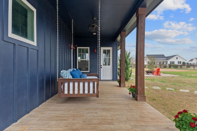 wooden terrace with a porch and a lawn