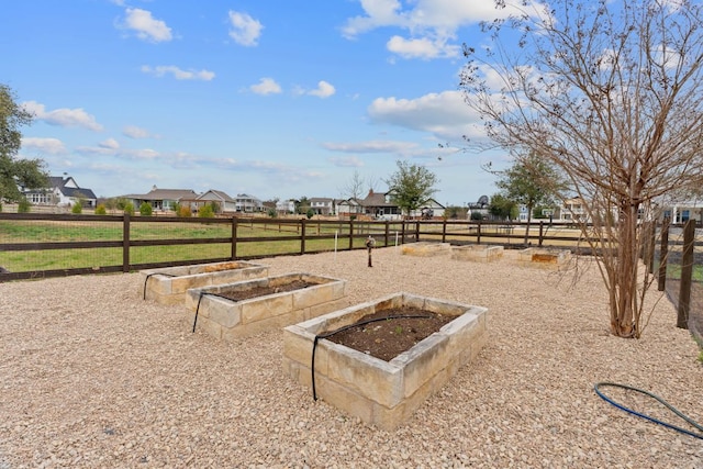 view of yard featuring a vegetable garden, a residential view, and fence