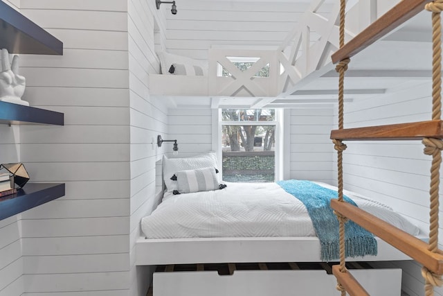 bedroom featuring wooden walls