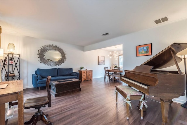 living area with a notable chandelier, baseboards, visible vents, and wood finished floors