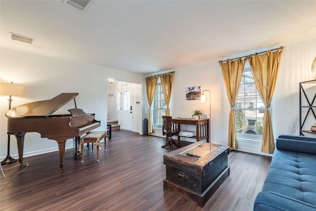 living room with visible vents, baseboards, and wood finished floors