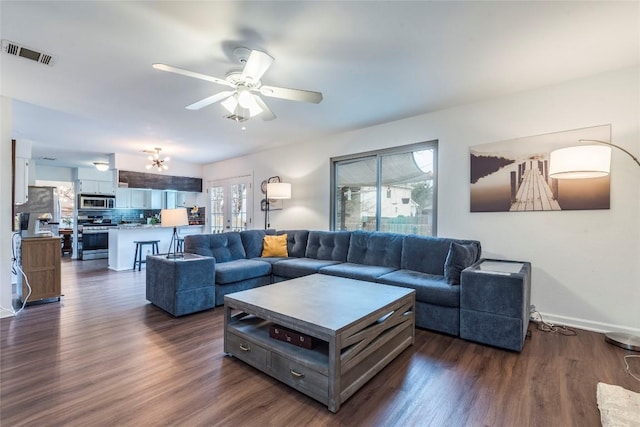 living area featuring dark wood-style floors, ceiling fan, visible vents, and baseboards